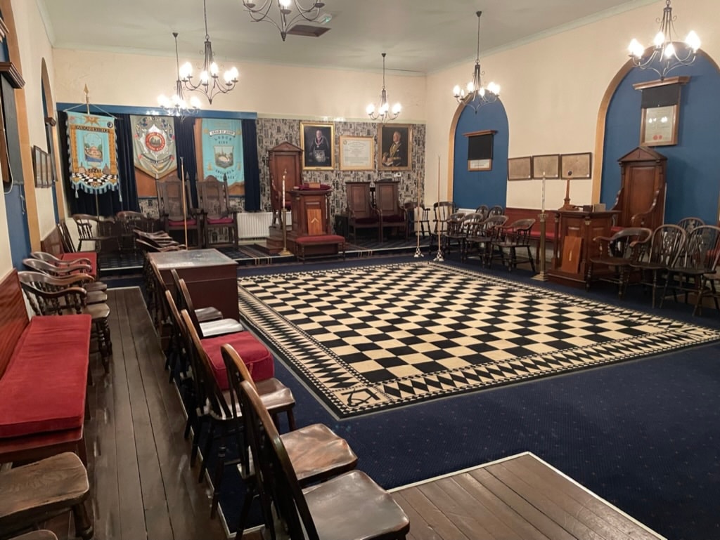 The interior of David Garrick Lodge room showing the black and white chequered floor, red chairs and ceremonial furnishings